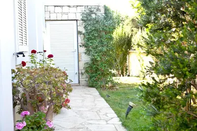 an entrance to a garden with a door and flowers at Rodanthi Villas in Darmarochori