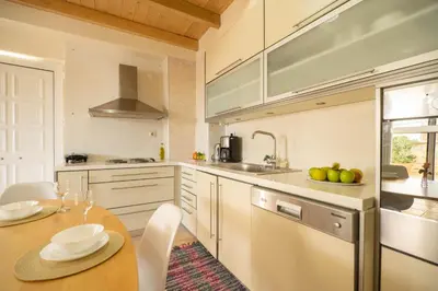 a kitchen with a wooden table and a dining room at Rodanthi Villas in Darmarochori