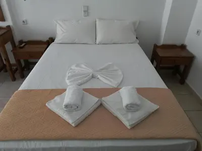 a bed with two towels with a bow on it at Karmi Apartments in Kolymvari