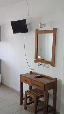 a table with a mirror on a wall next to a lamp at Karmi Apartments in Kolymvari