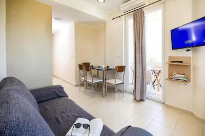 a living room with a couch and a table with chairs at Vasso Apartments in Kissamos