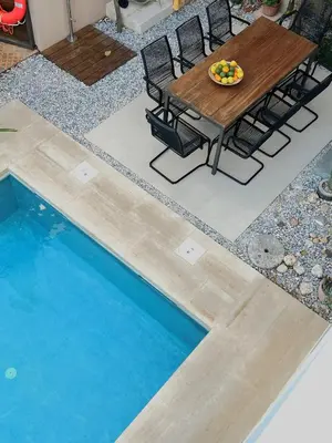 a dining table and chairs next to a swimming pool at Fos Villa, a Luxe House with Private Heated Pool in Galatás