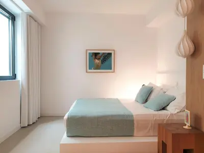 a bedroom with a bed in a white room at Fos Villa, a Luxe House with Private Heated Pool in Galatás