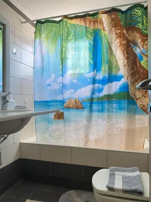 a bathroom with a shower curtain with a beach at Maria & Zachos House in Kissamos