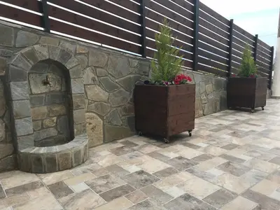 a patio with two potted plants and a stone wall at Maria & Zachos House in Kissamos