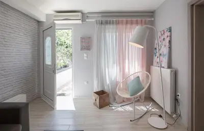 a living room with a chair and a door at Chalepa Boutique Apartment in Chania Town