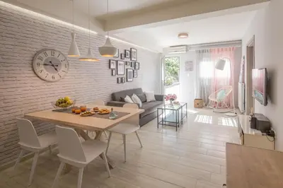 a kitchen and living room with a table and a clock at Chalepa Boutique Apartment in Chania Town