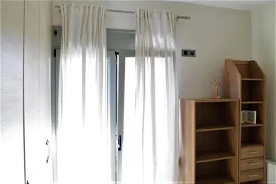 a room with a window with white curtains and a mirror at Casa Ariadne in Plataniás