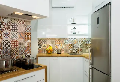a kitchen with white cabinets and a stainless steel refrigerator at Elmaya's Duplex in Kissamos