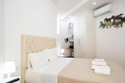 a white bedroom with a large bed with towels on it at Elmaya's Duplex in Kissamos