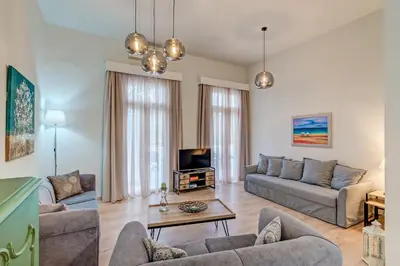 a living room with a couch and a tv at Grande Casa 1926 in Chania Town