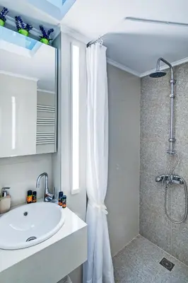 a white bathroom with a sink and a shower at Casa 1926 in Chania Town
