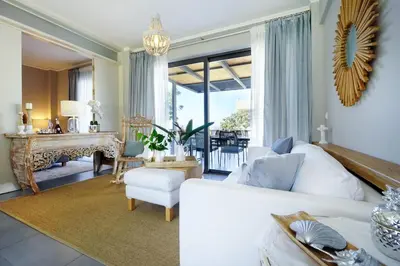 a living room with a white couch and a table at 3 bdr apartment 5 km from the city in Agios Onoufrios
