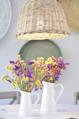 two white vases sitting on a table with flowers at 3 bdr apartment 5 km from the city in Agios Onoufrios