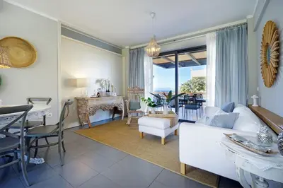 a living room with a white couch and a table at 3 bdr apartment 5 km from the city in Agios Onoufrios