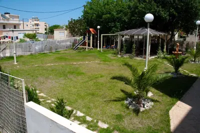 a small yard with a playground with a palm tree at Rastoni Apartments in Kissamos