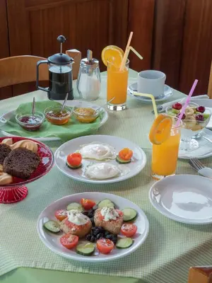 a table topped with plates of food and orange juice at Petritos Rooms and Studios in Falasarna
