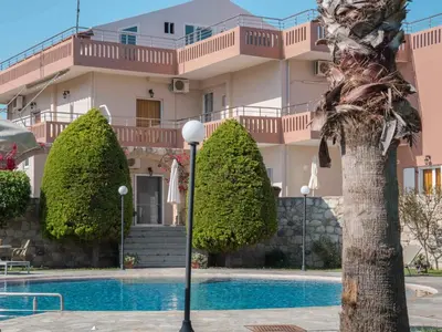 a building with a swimming pool in front of a building at Petritos Rooms and Studios in Falasarna