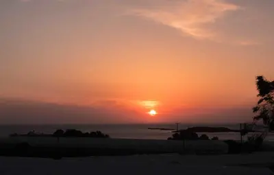 a sunset on the beach with the sun setting at Petritos Rooms and Studios in Falasarna