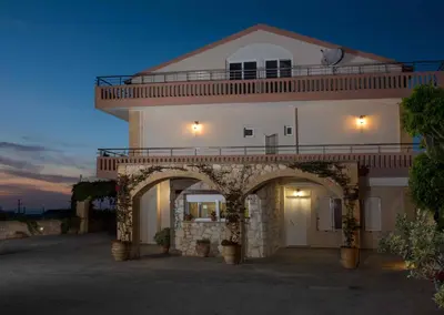 a large white building with an archway at night at Petritos Rooms and Studios in Falasarna