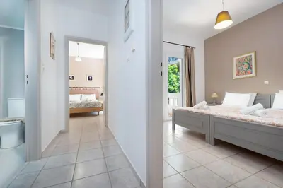 a bedroom with a bed and a bathroom at Aptera Beach Apartment in Kato Daratso