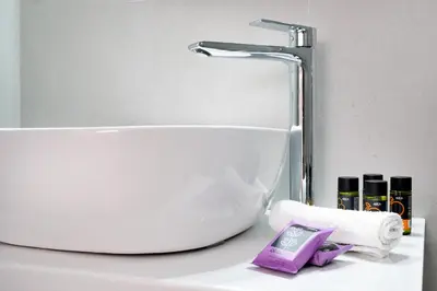 a bathroom sink with a faucet and a roll of toilet paper at Aptera Beach Apartment in Kato Daratso