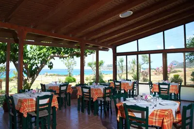 a restaurant with tables and chairs with a view of the ocean at Kalami Rooms in Falasarna
