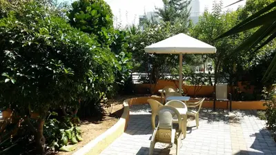 a patio with tables and chairs and an umbrella at Alexandros Studios & Apartments in Chania Town