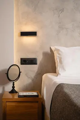 a bedroom with a bed and a mirror on a night stand at Morfeas Hotel in Chania Town