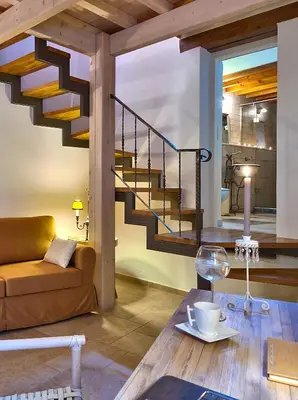 a living room with a staircase and a table at Kores Boutique Houses in Chania Town