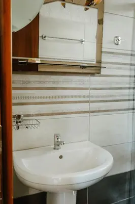 a bathroom with a white sink and a mirror at Konaki Apartments in Maleme