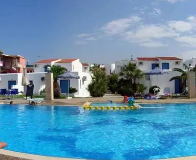 a large blue swimming pool with buildings in the background at Marina Sands in Agia Marina Nea Kydonias