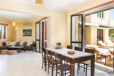 a living room with a table and chairs at Daphnis Villas in Maleme