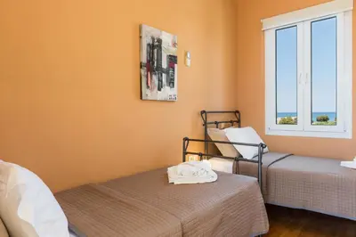 a room with two beds and a window at Daphnis Villas in Maleme