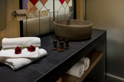 a bathroom with towels and a sink on a counter at ELG Contessa Boutique Hotel in Chania Town