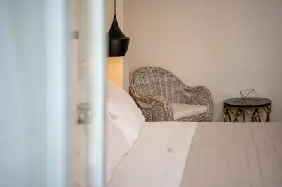 a bedroom with a white bed and a chair at Aoria Estate Old Port in Chania Town