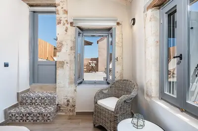 a balcony with a wicker chair and a window at Aoria Estate Old Port in Chania Town