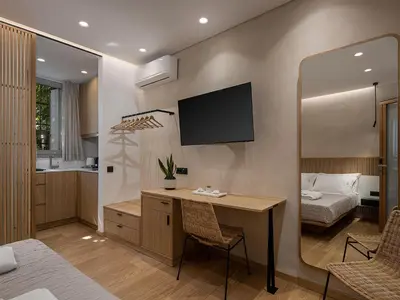 a room with a desk and a bed and a television at Aoria Estate Old Port in Chania Town