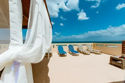 a view of a balcony with chairs and an umbrella at Asterina Seaside Apartments in Kalyves