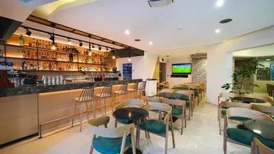 a restaurant with a bar with stools at Marika Beach Hotel in Plataniás