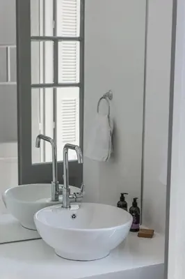 a bathroom with a white sink and a mirror at Kumba in Chania Town
