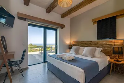 a bedroom with a bed with a view of the ocean at Aspalathos Falassarna Villas in Falasarna