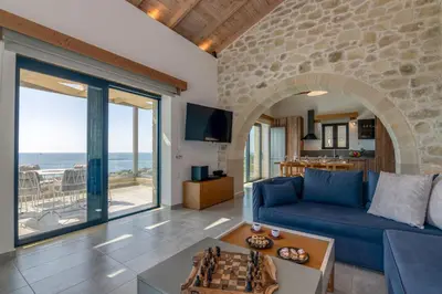 a living room with a blue couch and a table at Aspalathos Falassarna Villas in Falasarna