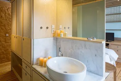 a bathroom with a sink and a large mirror at Olea Villas - Infinity Pool, Hot Tub, Sea Views in Marathi