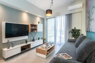 a living room with a gray couch and a flat screen tv at Mediterranean Luxury Apartment in Chania Town