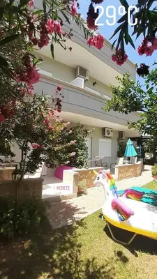 a house with a surfboard in front of it at Marianna Apartments in Almirida