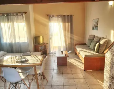a living room with a bed and a table and chairs at Marianna Apartments in Almirida
