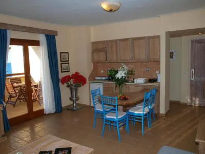 a kitchen with blue chairs and a wooden table at Mylos Hotel Apartments in Plataniás