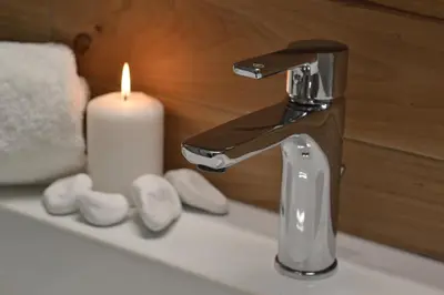 a bathroom sink with a faucet and a candle at Agapi Suites in Chania Town