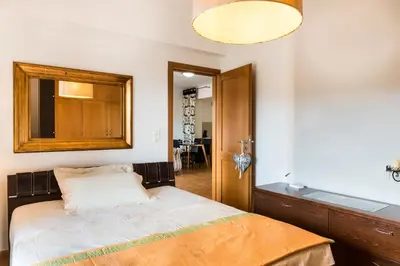 a bedroom with a bed and a mirror on the wall at Zen Serenity Retreat with Great Outdoors, Pool & Parking in Áptera
